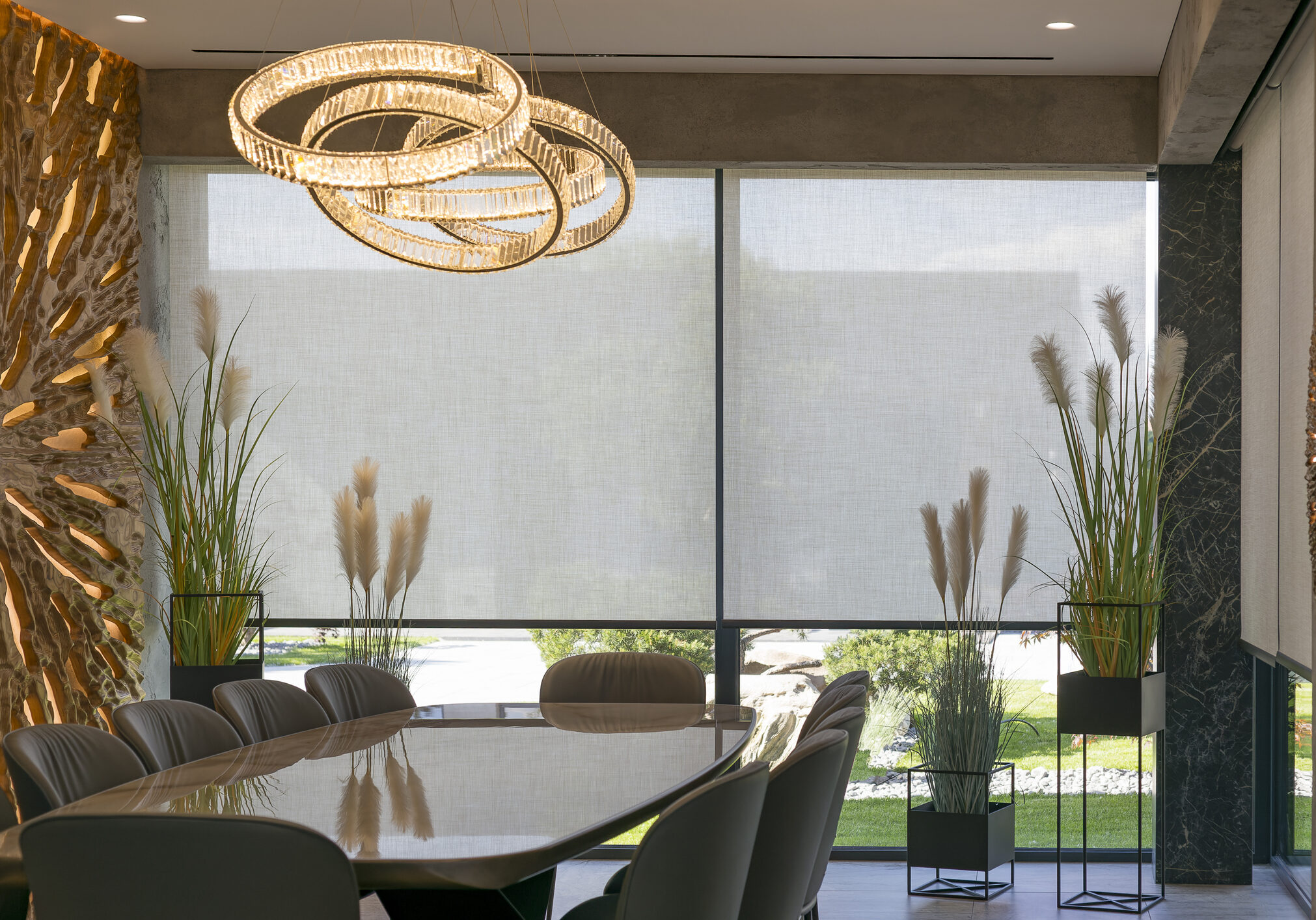 Roller blinds in the interior. Automatic solar shades large size on the window. Modern interior with wood decor panel on the wall. Green plants in hi-tech flower pots. Electric curtains for home.